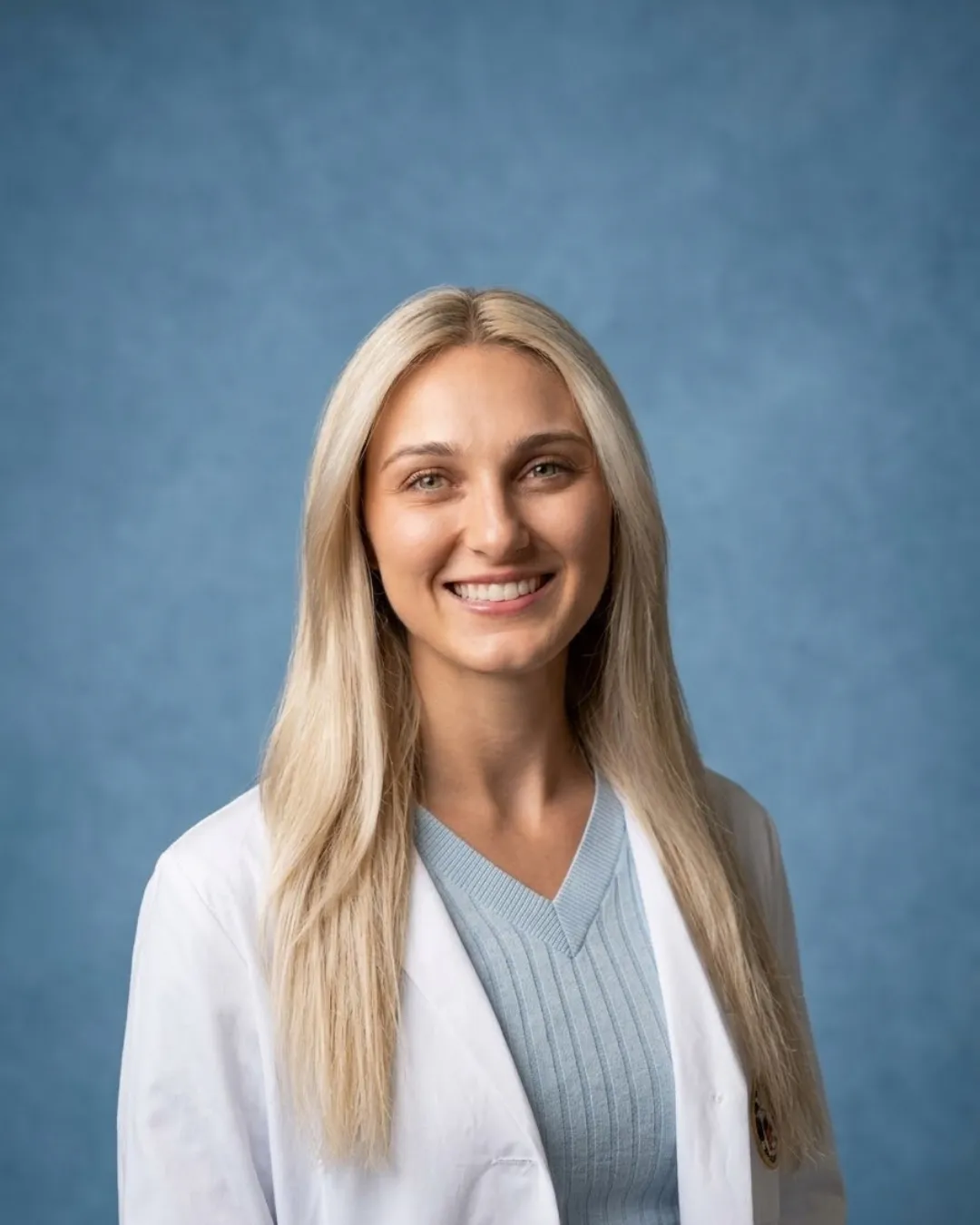 Sarah Caprio, FNP-C, smiling in a white coat